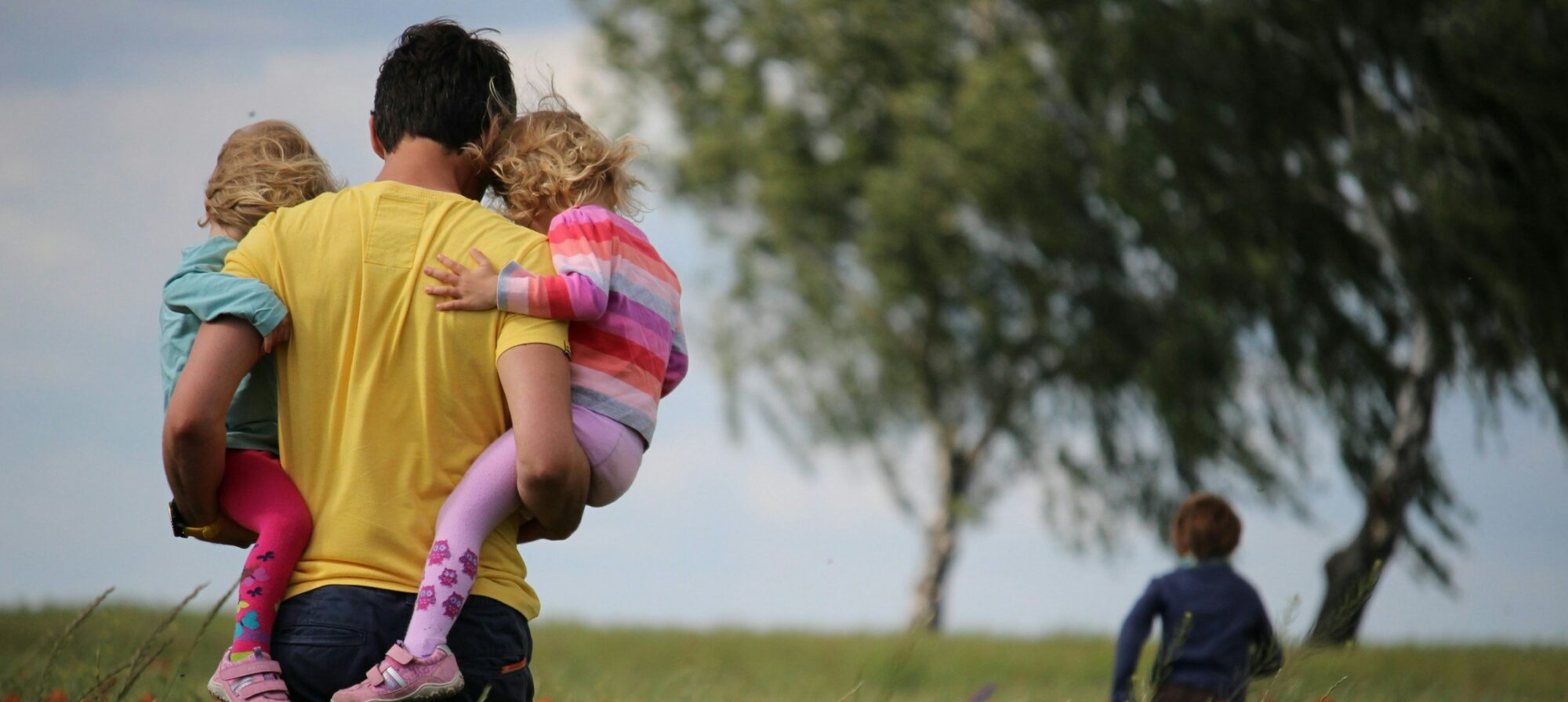 Bambino piccolo in braccio a un adulto all’aperto